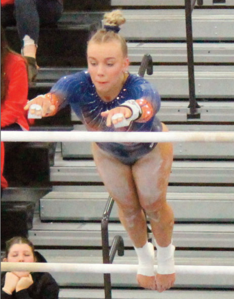 Dodgeville Co-Op' junior Maddy Klein goes from the low bar to the high one at Sectionals. John Dalton photo.