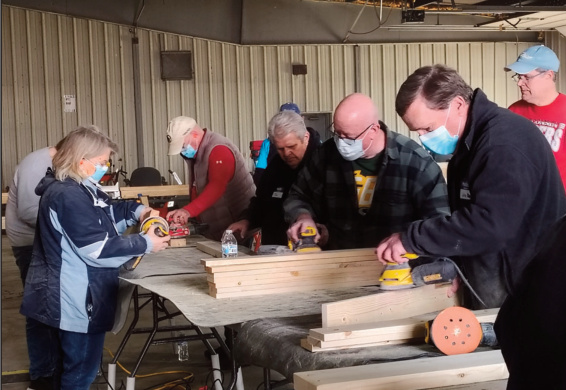 People sanding the wood planks