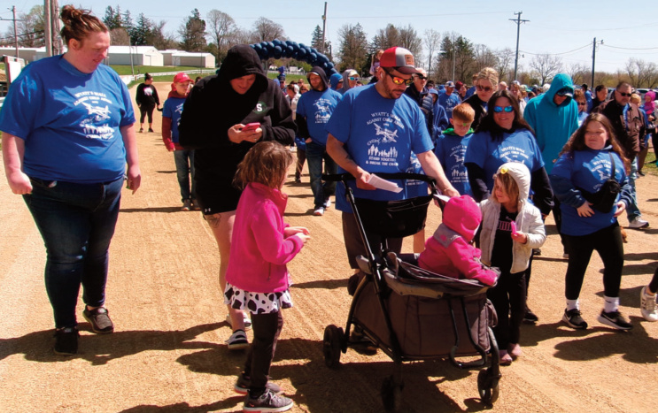 This photo from 2025 shows people on the Iowa County Fairgrounds track dur- ing the first Wyatt's Walk. The child abuse prevention and awareness event will be April 25 this year.