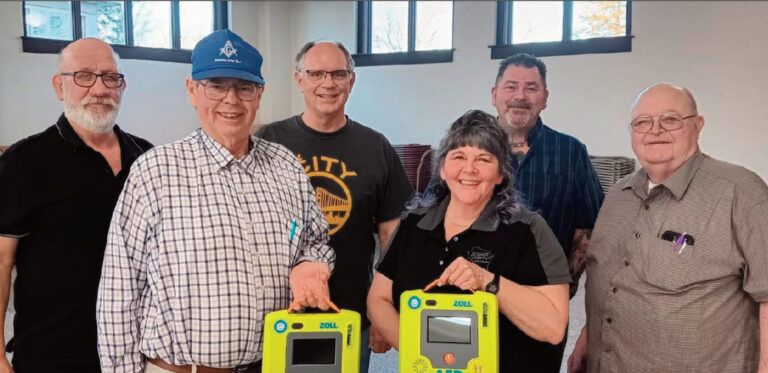 Members of the Dodgeville Masonic Temple Lodge 119 recently presented Iowa County with two new AED units. An AED (Automated External Defibrillator) is a portable device used to help people experiencing sudden cardiac arrest. The lowa County Facilities and Grounds Department will use the donation towards updating life-saving equipment in several county buildings, including the Courthouse, Health and Human Services, and the Highway Department's Main Shop. Pictured left to right: Brad Pishion, Orville Olson, Scott Alhaus, Dawn Foreman, Rick Abing, and Jim Heisner. Behind the Camera Ross Jones.