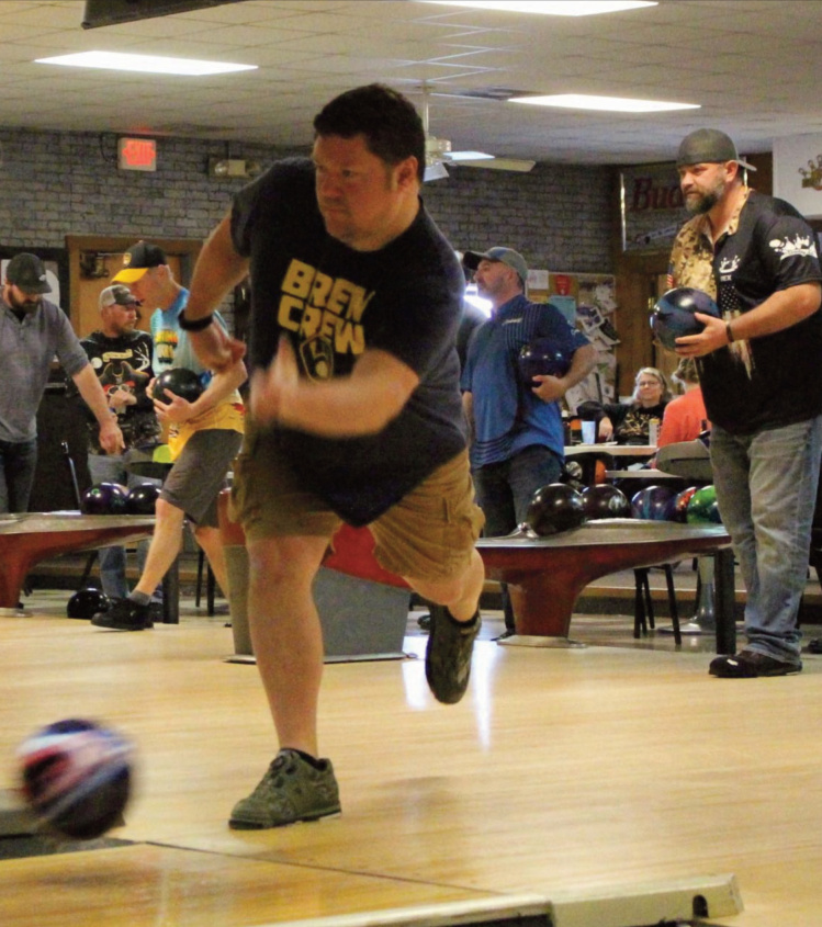 Bowler Kyle Schommer throws a ball Saturday while Rex U'ren awaits his turn behind him.