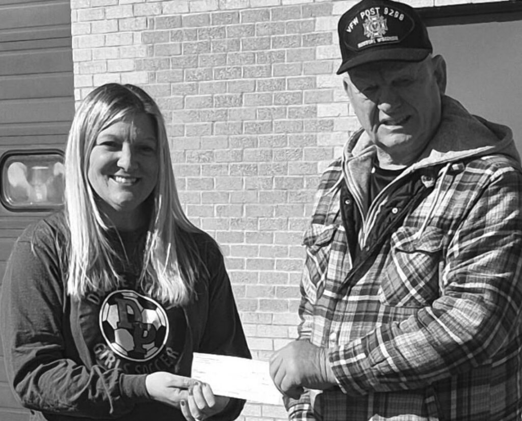 John Kohout, representing the Ritchie-Bowers-Kohout Post 9298 Montfort VFW, presents a donation to Cobb Public Li- brary Director Carrie Jewell in support of local library services.