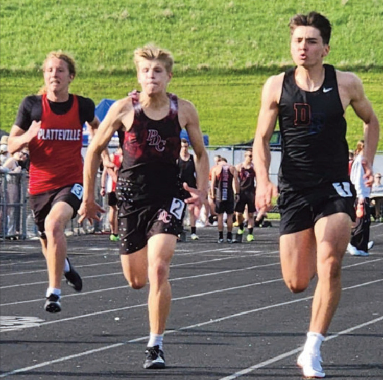 Dodge-Point's Evan Ensrude runs hard to stay in front of A Richland Center opponent in the 100. Photo by Amy Robinson.