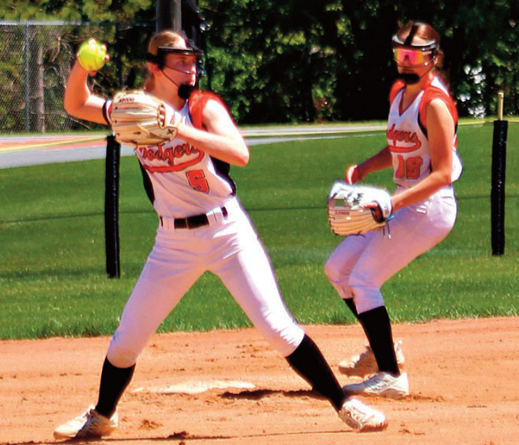 Emma Dougherty throws to first from her shortstop position with Mikayla La- throp also in the action. Photo by Angie Borne.