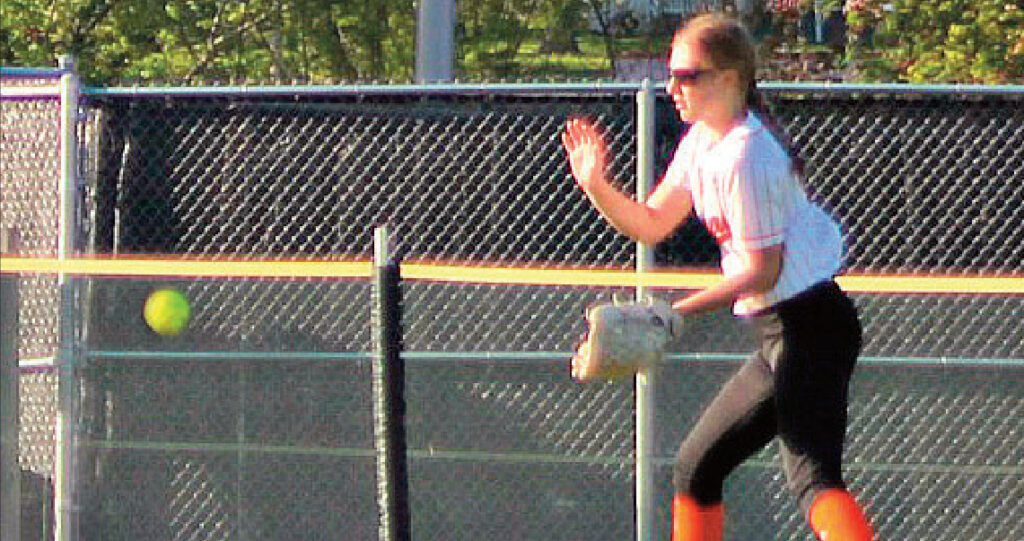 Kendra Brom fields a ball in the outfield. Photo by Angie Borne.