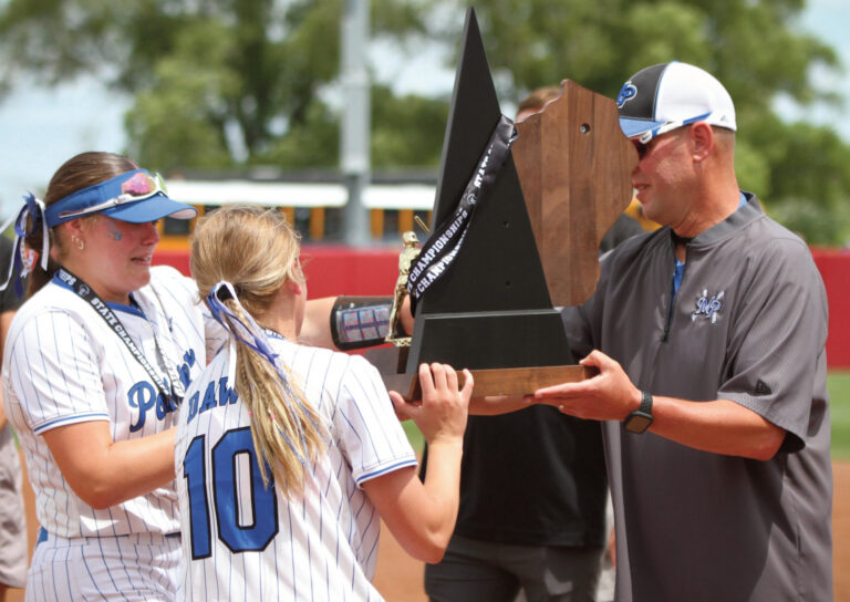 Pointers seniors Maddy Kabat and Jadyn Schults take the championship trophy from Coach Quinn Schultz