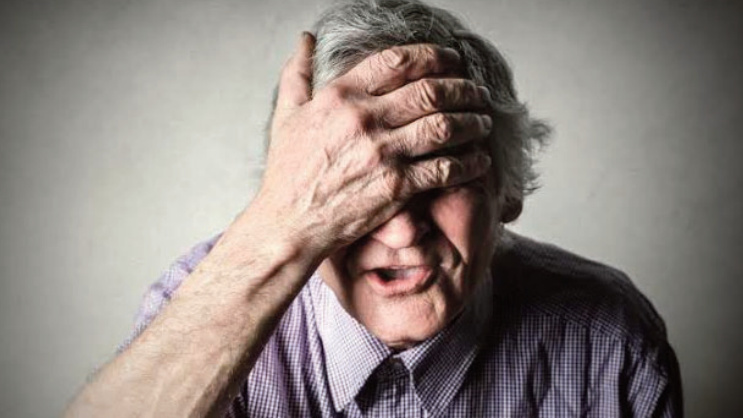 man with hand on head