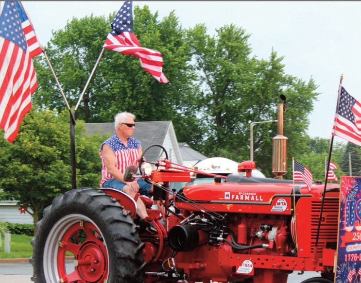 Man driving tractor through parade
