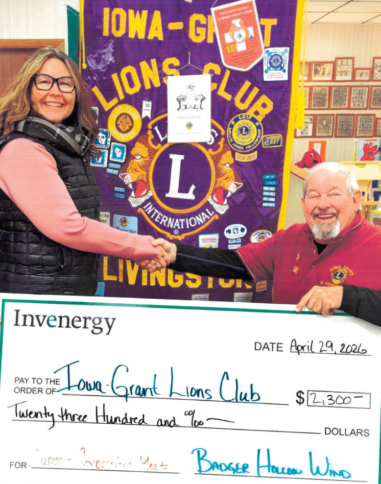 Iowa-Grant Lions Club Secretary Jerry Smalley accepts a donation from Tracy Fillback of Invenergy