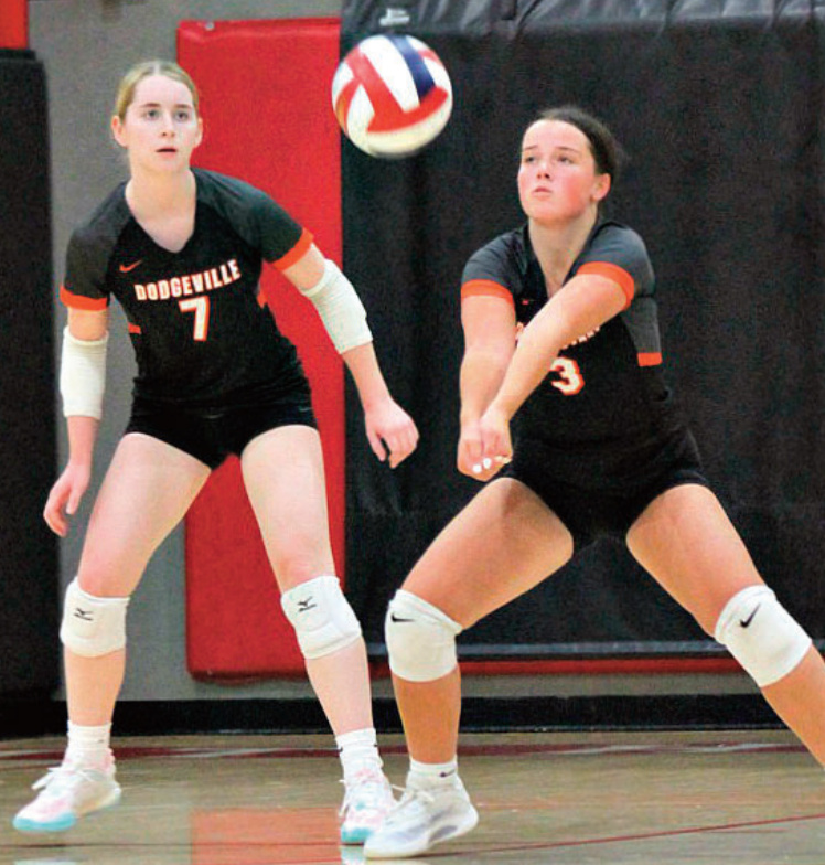 Lydia Reilly bumps a shot to the front row. Looking on is Emma Doug- herty (7). Photo by Angie Borne.