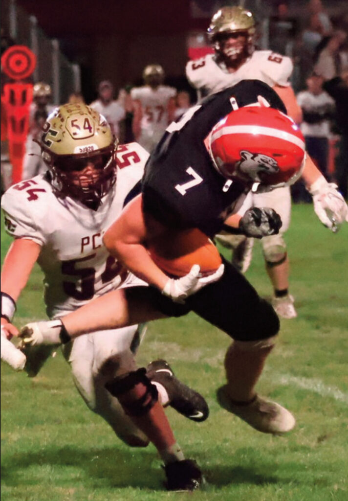 Cole Schauff dives for extra yardage as he is brought down. Photo by David Friesen.
