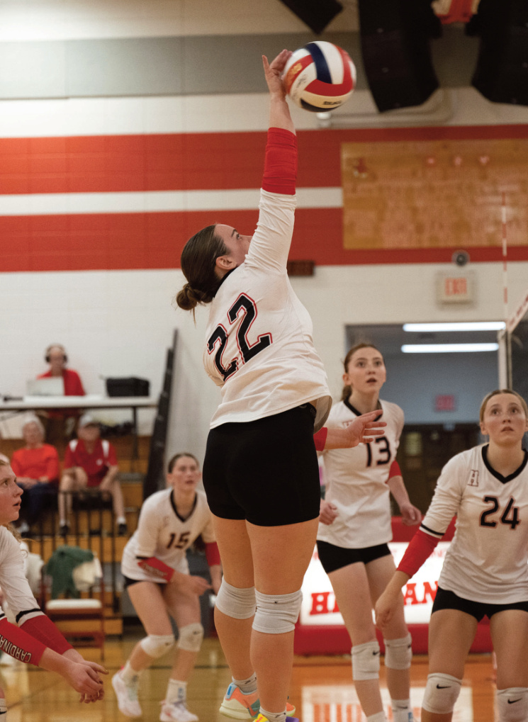 Highland's Marissa Biba puts a shot over the net with teammates Celia Oleson (15), Addily Esser (13) and Ava Michek (24) watching the shot. Photo by Jonelle Degenhardt.